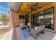 Inviting covered patio with brick accents, comfortable seating, and outdoor television at 1131 S York St, Denver, CO 80210