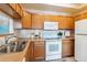 Modern kitchen, featuring white appliances and wood cabinets at 990 S Locust St # D, Denver, CO 80224