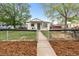 This charming home features a freshly painted exterior and a welcoming covered front porch and fenced yard at 6980 Niagara St, Commerce City, CO 80022