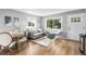 Bright living room with wood floors, white walls, and a large window providing natural light at 6980 Niagara St, Commerce City, CO 80022