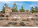 Stone community sign for Candelas with native plants and shrubbery in the foreground at 9382 Pike Way, Arvada, CO 80007