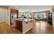 Open kitchen featuring stainless steel appliances, granite counters, and hardwood floors adjacent to living area at 9382 Pike Way, Arvada, CO 80007