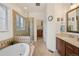 Bright main bathroom boasts a soaking tub, glass shower, and a walk-in closet at 9382 Pike Way, Arvada, CO 80007