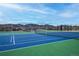Well maintained tennis courts with mountain views and surrounding neighborhood in the background at 9382 Pike Way, Arvada, CO 80007