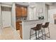 Convenient lower level wet bar with a stylish counter, cabinets, and bar stool seating at 9382 Pike Way, Arvada, CO 80007