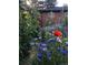 Brick house behind a garden with a colorful assortment of flowers at 1695 S Beach Ct, Denver, CO 80219