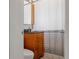 Cozy bathroom with wooden vanity, granite countertop, and shower with striped curtain at 1695 S Beach Ct, Denver, CO 80219