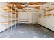 Unfinished garage with exposed beams, concrete flooring, and built-in shelving at 1695 S Beach Ct, Denver, CO 80219