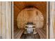 The interior of the wood-paneled barrel sauna, featuring benches, a heater, and natural light at 1695 S Beach Ct, Denver, CO 80219
