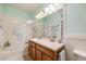 Bright bathroom featuring a double sink vanity, tiled shower and tub combination at 15700 E Jamison Dr # 6-101, Englewood, CO 80112