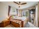 Cozy bedroom with plush carpet, ceiling fan, large window, and wooden furniture at 15700 E Jamison Dr # 6-101, Englewood, CO 80112