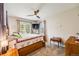 Bright bedroom with ceiling fan, natural light, carpeted floor, and wooden furnishings at 15700 E Jamison Dr # 6-101, Englewood, CO 80112