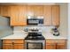 Close-up shot of an updated kitchen featuring oak cabinets, stainless steel appliances and subway tile backsplash at 15700 E Jamison Dr # 6-101, Englewood, CO 80112