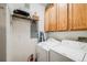 Functional laundry room with washer, dryer, cabinets, and storage shelf at 15700 E Jamison Dr # 6-101, Englewood, CO 80112