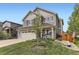 Charming two-story home featuring a well-manicured lawn, complemented by a welcoming front porch with seating at 2115 Coach House Loop, Castle Rock, CO 80109