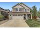 Charming two-story house with a two car garage, well-kept lawn and landscaping plus covered porch with rocking chairs at 2115 Coach House Loop, Castle Rock, CO 80109