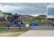 A blue and red playground structure at the elementary school, viewed from the blacktop at 2115 Coach House Loop, Castle Rock, CO 80109
