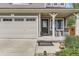 Close-up view of a charming covered porch with rocking chairs, and a two car garage with multi-pane windows at 2115 Coach House Loop, Castle Rock, CO 80109