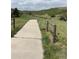 Cement walking path surrounded by grass, featuring a split rail fence at 2115 Coach House Loop, Castle Rock, CO 80109