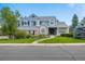 Inviting two-story blue home with well-manicured lawn and mature trees at 1496 Meyerwood Cir, Highlands Ranch, CO 80129