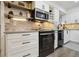Close-up of a modern kitchen featuring stainless steel appliances, white cabinets, and stylish backsplash at 6948 Buckskin Dr, Littleton, CO 80125