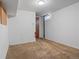 Unfinished basement space with carpeting, white walls, and natural light from small window at 8481 E Briarwood Blvd, Centennial, CO 80112