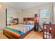 Bright bedroom featuring a mirrored closet, wood floors and a colorful bedspread at 8481 E Briarwood Blvd, Centennial, CO 80112