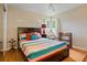 Bedroom with colorful bedding, wood floors, and natural light from a large window at 8481 E Briarwood Blvd, Centennial, CO 80112