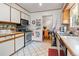 Practical kitchen featuring white cabinets, stainless steel appliances, and an open layout to the dining room at 8481 E Briarwood Blvd, Centennial, CO 80112