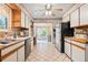 Traditional style kitchen with white cabinetry, wood trim, and modern appliances and a view to a breakfast nook at 8481 E Briarwood Blvd, Centennial, CO 80112