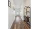 A bright hallway with wood floors, white walls, and stylish decor leading to the front door at 4422 Mt Shavano St, Brighton, CO 80601