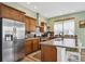 Modern kitchen boasts stainless steel appliances, wooden cabinets, and a center island with seating at 4422 Mt Shavano St, Brighton, CO 80601