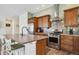 Well-equipped kitchen with stainless steel appliances, wood cabinets, and eat-in island at 4422 Mt Shavano St, Brighton, CO 80601