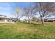 Spacious backyard with a large grassy area, mature trees, and a view of neighboring homes at 7309 W Hampden Ave # 601, Lakewood, CO 80227