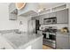 Modern kitchen with stainless steel appliances, granite countertops, and gray cabinets at 7309 W Hampden Ave # 601, Lakewood, CO 80227