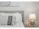 A close up of a main bedroom, showcasing a stylish bedside table and soft, neutral bedding at 7309 W Hampden Ave # 601, Lakewood, CO 80227