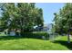 Large backyard with mature trees, deck and green lawn provides a perfect setting for outdoor activities at 12651 E Bates Cir, Aurora, CO 80014