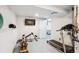 Home basement gym with treadmill, rowing machine and mounted television at 12651 E Bates Cir, Aurora, CO 80014