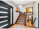 Grand foyer with wood floors, modern staircase, stylish lighting, and artful design elements at 12651 E Bates Cir, Aurora, CO 80014