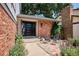Inviting front entrance with brick facade, modern seating, and vibrant flowers, and well-manicured landscaping at 12651 E Bates Cir, Aurora, CO 80014