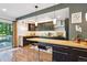 Modern kitchen with wood countertop breakfast bar, dark cabinets and stainless steel appliances at 12651 E Bates Cir, Aurora, CO 80014