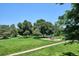 Green park with mature trees, playground, and walking path offers a peaceful outdoor experience at 12651 E Bates Cir, Aurora, CO 80014