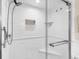 All-white tiled shower featuring glass doors and a shower head at 1200 N Humboldt St # 1003, Denver, CO 80218