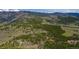 Expansive aerial view of a modern home surrounded by a lush forest and a majestic mountain backdrop at 586 Alpine Way, Idaho Springs, CO 80452