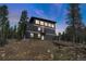 Striking modern exterior with balconies and a spacious two-car garage, set against a forested backdrop at 586 Alpine Way, Idaho Springs, CO 80452