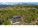 Stunning exterior with solar panels amidst lush forest and mountain views in an elevated setting at 586 Alpine Way, Idaho Springs, CO 80452