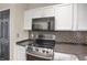 Modern kitchen features stainless steel appliances, mosaic backsplash, and white cabinets at 18206 E Tanforan Pl, Aurora, CO 80015