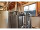 Bright laundry room featuring modern washer and dryer next to a window, paired with water heater at 18206 E Tanforan Pl, Aurora, CO 80015