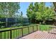 Backyard featuring a wood deck, lush greenery, and a wooden fence, designed for outdoor relaxation and entertainment at 5651 S Himalaya Way, Centennial, CO 80015