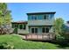 Two-story home has a backyard with lush lawn, mature trees, and a private wooden deck at 5651 S Himalaya Way, Centennial, CO 80015